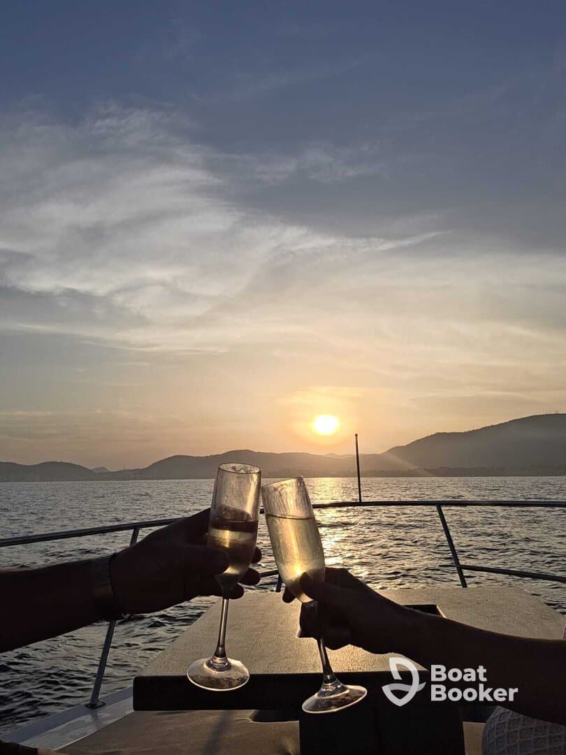 A couple toasts with champagne glasses against a stunning sunset backdrop, creating a romantic atmosphere perfect for sunset cruises.