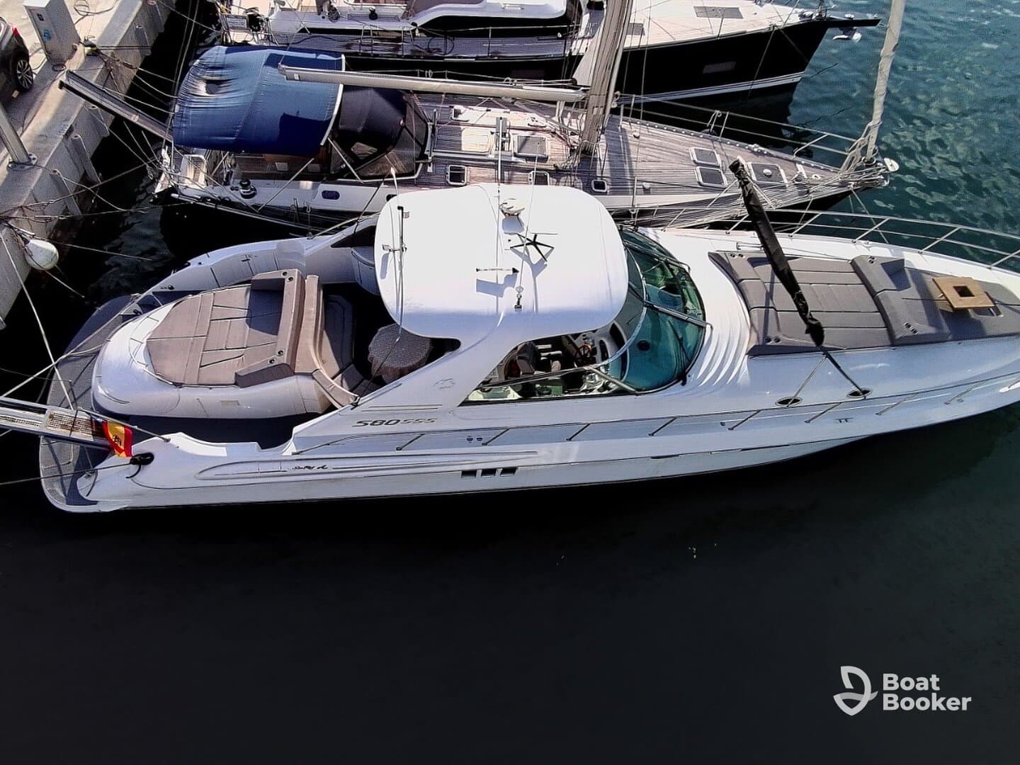 Aerial view of a sleek yacht docked at the marina, showcasing its elegant design and spacious deck — perfect for luxury cruising.