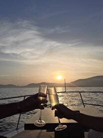 A couple toasts with champagne glasses against a stunning sunset backdrop, creating a romantic atmosphere perfect for sunset cruises.
