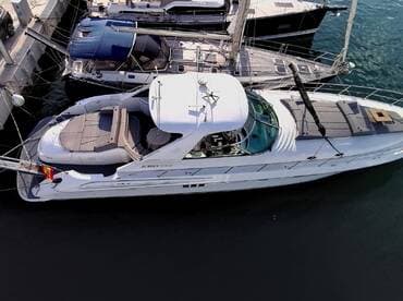 Aerial view of a sleek yacht docked at the marina, showcasing its elegant design and spacious deck — perfect for luxury cruising.