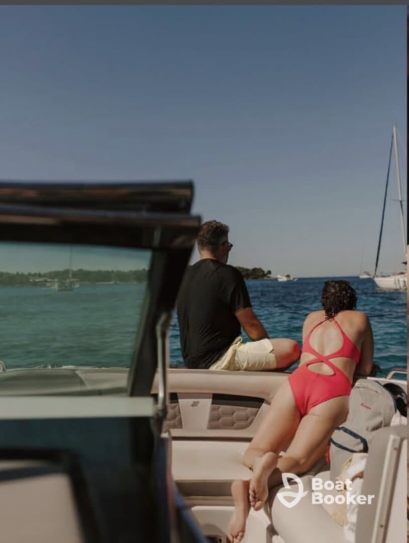 A couple enjoys a relaxing moment on a boat, taking in the beautiful water views — perfect for summer getaways and romantic outings.