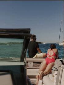 A couple enjoys a relaxing moment on a boat, taking in the beautiful water views — perfect for summer getaways and romantic outings.