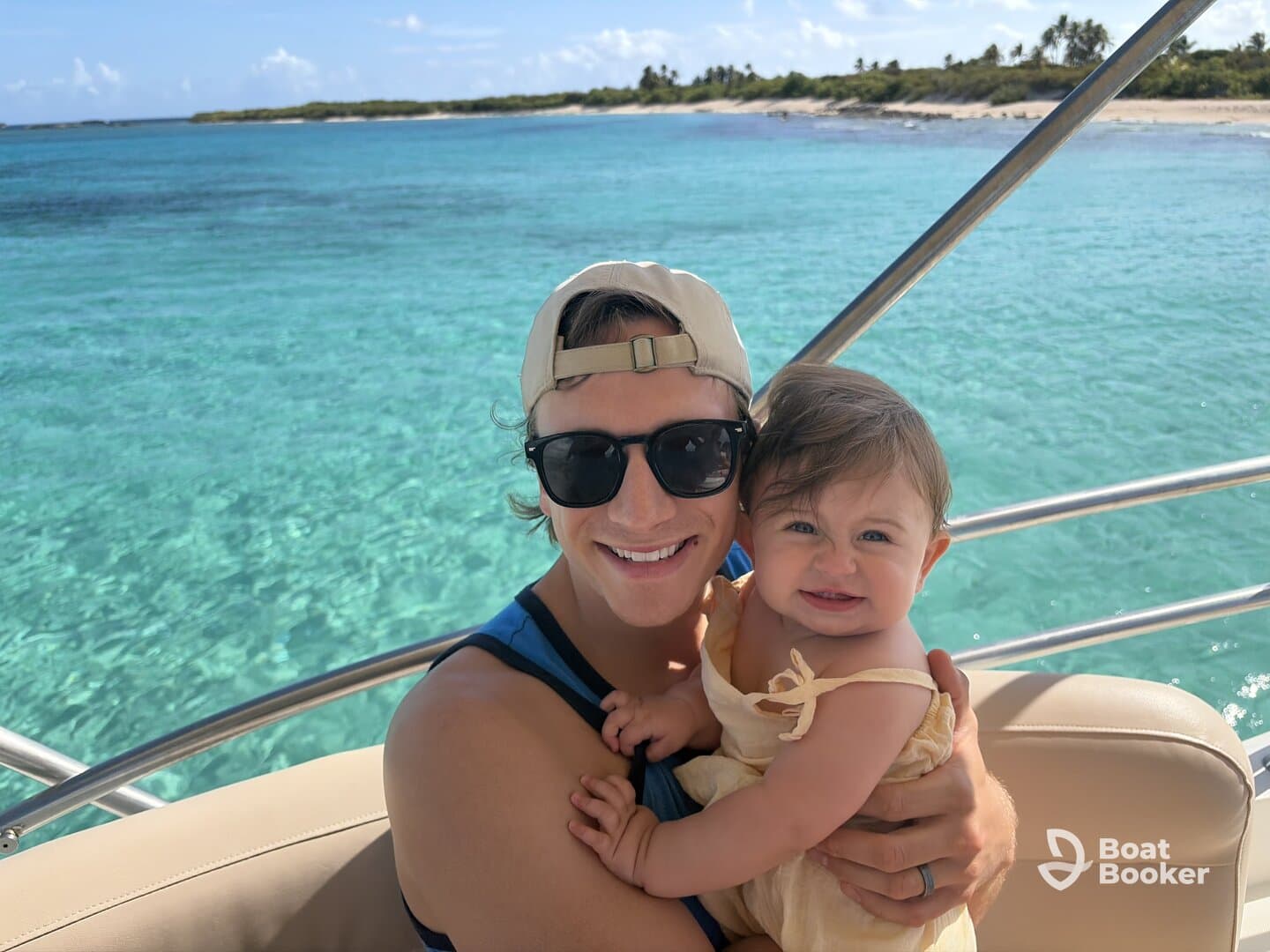 A joyful moment captured on a boat, featuring a smiling father holding his baby against a stunning ocean backdrop — perfect for family outings on the water.