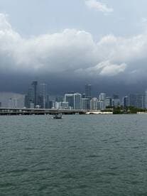 A stunning view of the Miami skyline from the water, showcasing the vibrant cityscape against a dramatic sky — perfect for capturing the essence of urban waterfront adventures.