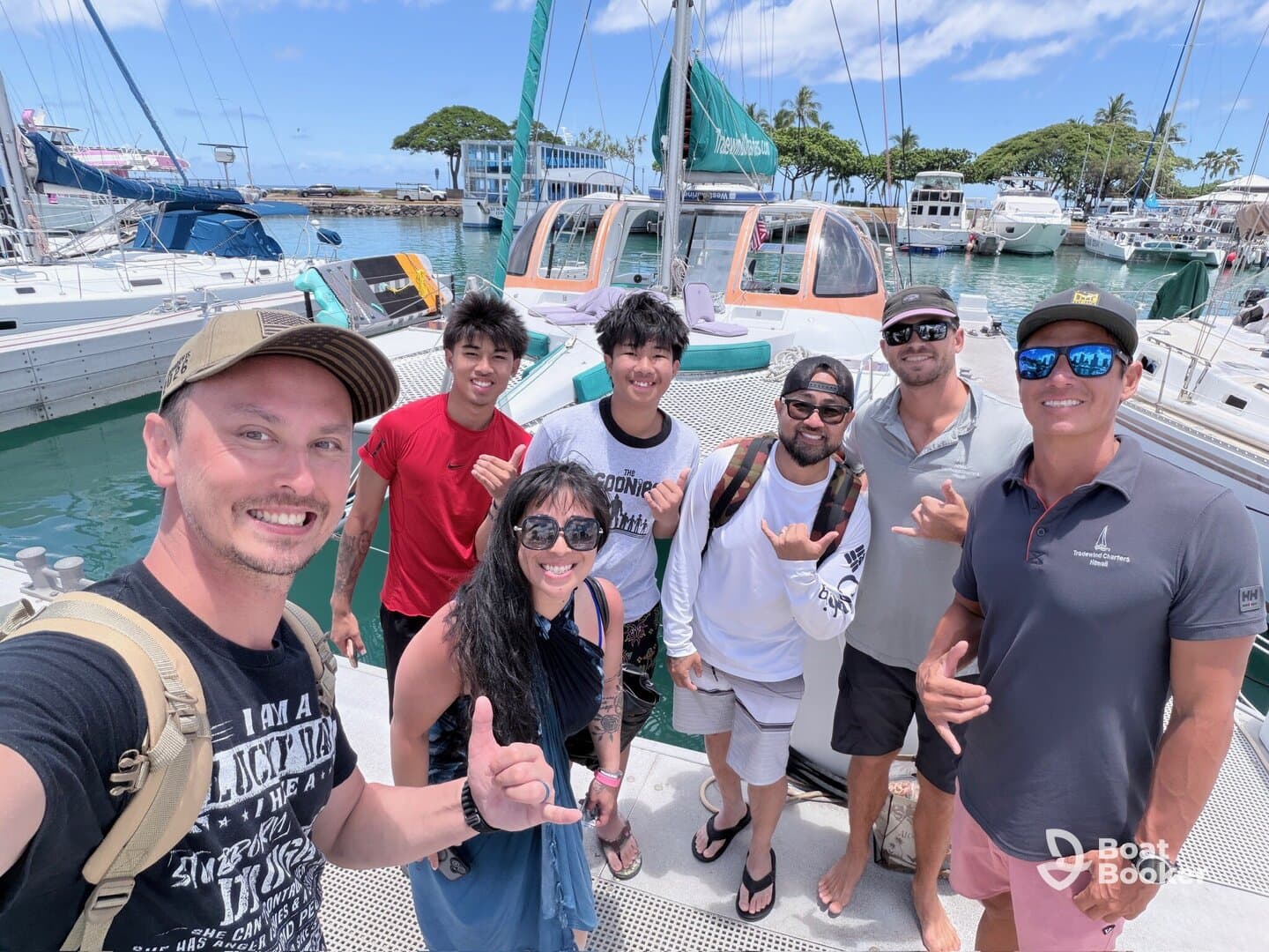 A cheerful group of friends poses for a photo on the deck of a boat, capturing the excitement of their day on the water.