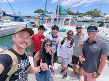 A cheerful group of friends poses for a photo on the deck of a boat, capturing the excitement of their day on the water.