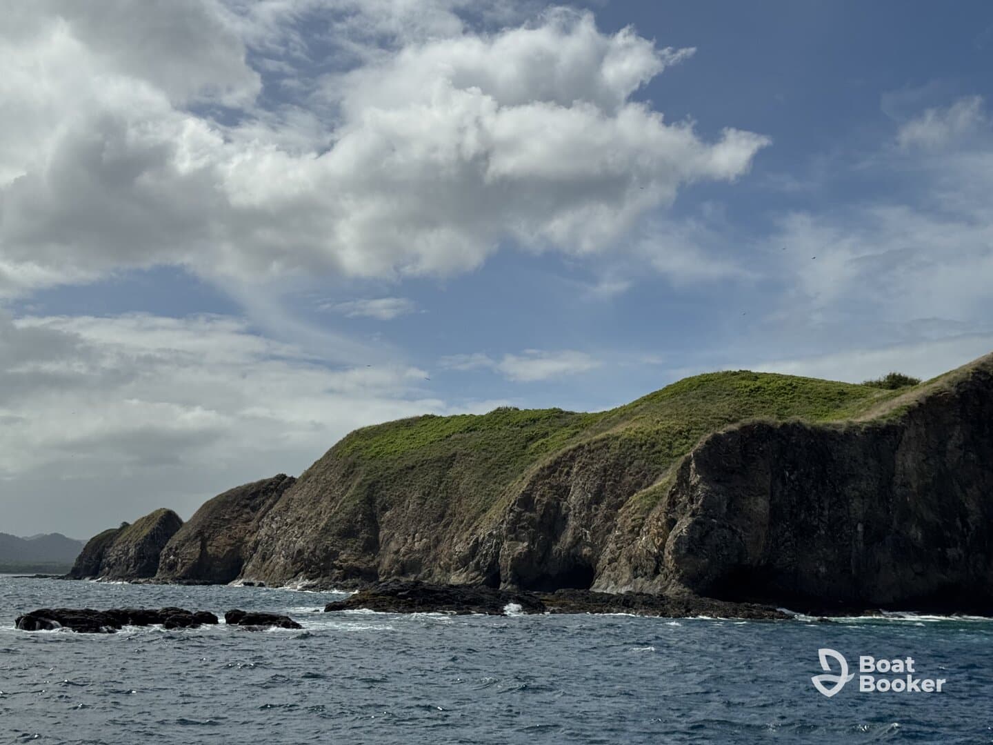 A stunning view of a rugged coastline with lush green hills under a partly cloudy sky, perfect for showcasing the natural beauty of the region.
