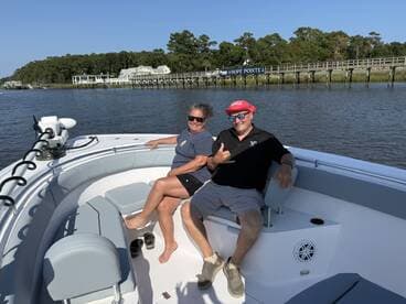 A cheerful couple enjoys a relaxing moment aboard a boat, showcasing the perfect setting for leisurely outings on the water.