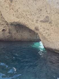 An unclear view of a rocky formation above water, lacking identifiable features or subjects.
