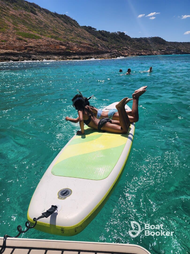 A group enjoys a fun day of paddleboarding and swimming in crystal-clear waters, perfect for snorkeling adventures and beach outings.