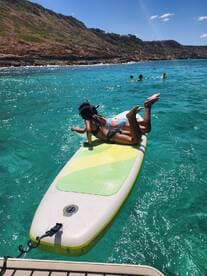 A group enjoys a fun day of paddleboarding and swimming in crystal-clear waters, perfect for snorkeling adventures and beach outings.