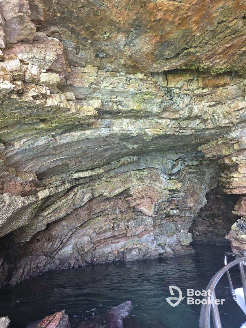 An unclear view of a rocky cave structure with water below, lacking identifiable features or subjects.