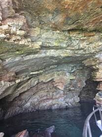 An unclear view of a rocky cave structure with water below, lacking identifiable features or subjects.