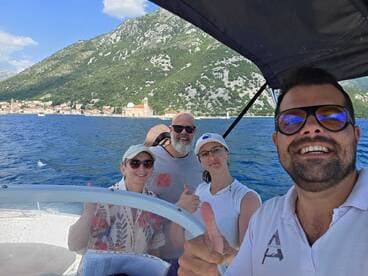A cheerful group of friends enjoys a day out on the boat, giving thumbs up against a picturesque coastal backdrop — perfect for memorable adventures on the water.