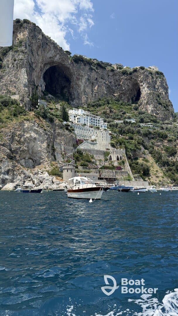 A picturesque view of a coastal landscape featuring a charming boat in the foreground and stunning cliffs and architecture in the background, perfect for showcasing the beauty of seaside adventures.