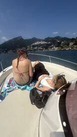 Two friends relax on the deck of a boat, enjoying the sun and scenic views — perfect for a day of leisure on the water.