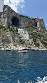 A picturesque view of a coastal landscape featuring a charming boat in the foreground and stunning cliffs and architecture in the background, perfect for showcasing the beauty of seaside adventures.