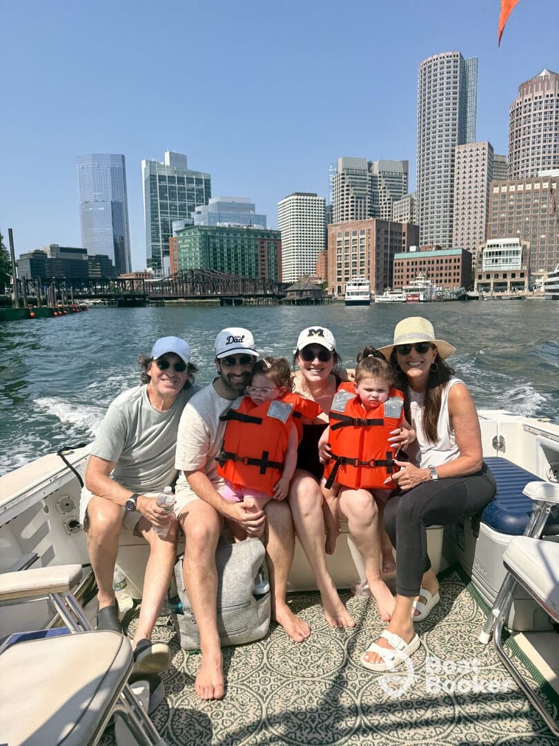 A joyful family enjoys a boat ride with a stunning city skyline in the background, all wearing life jackets for safety — a perfect day on the water.