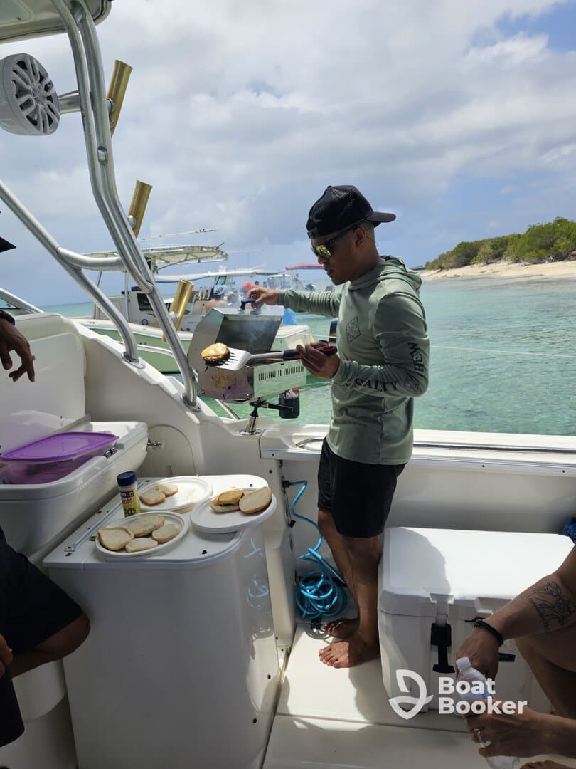 A chef prepares food on a grill aboard a boat, showcasing onboard dining amenities and a relaxed atmosphere for guests.
