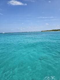 A stunning view of crystal-clear turquoise waters and a picturesque coastline, perfect for showcasing the beauty of a tropical getaway.