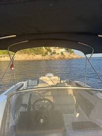 Interior view of a sleek boat's helm and seating area, showcasing a comfortable and stylish space for navigating the waters.