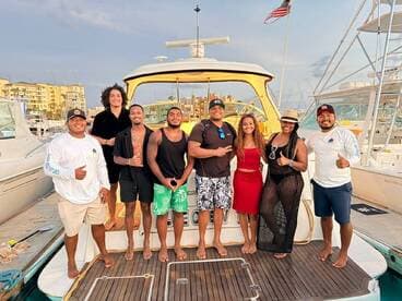 A cheerful group of friends poses on the deck of a boat, celebrating their time together — perfect for memorable outings and adventures on the water.