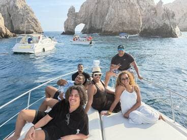 A lively group enjoys their time aboard a boat in Cabo San Lucas, capturing the essence of fun and adventure against a stunning coastal backdrop.