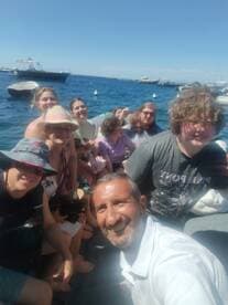 A cheerful group enjoys a fun day on the boat, capturing memories with smiles and laughter under the sun.
