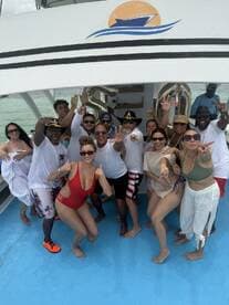 A lively group celebrates aboard a boat, showcasing joy and camaraderie in a perfect party atmosphere on the water.