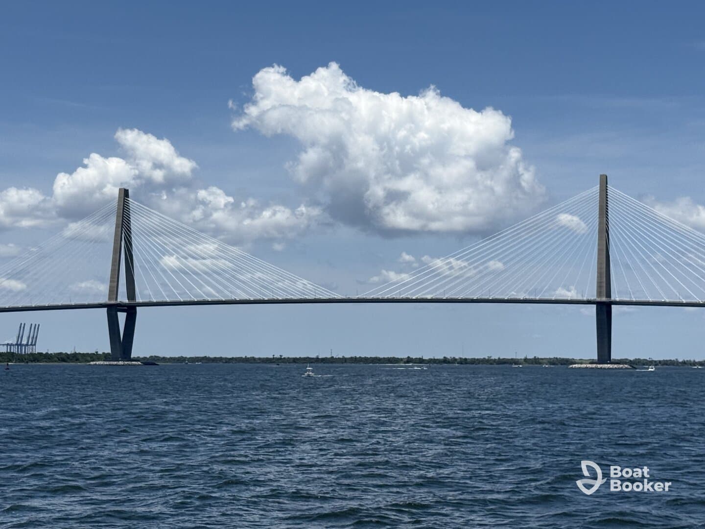 A scenic view of a bridge spanning over water, framed by a backdrop of clouds, showcasing the beauty of the landscape.