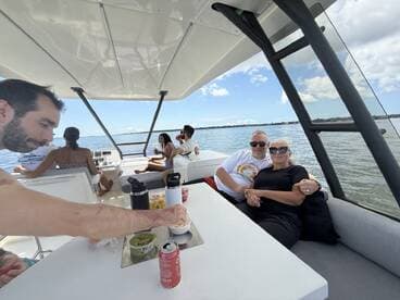 A couple enjoys a relaxing moment on a boat, surrounded by friends and refreshments, perfect for a day out on the water.