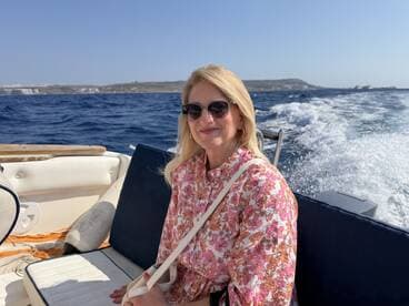 A woman enjoys a sunny day on a boat, capturing the essence of a relaxing trip on the water.