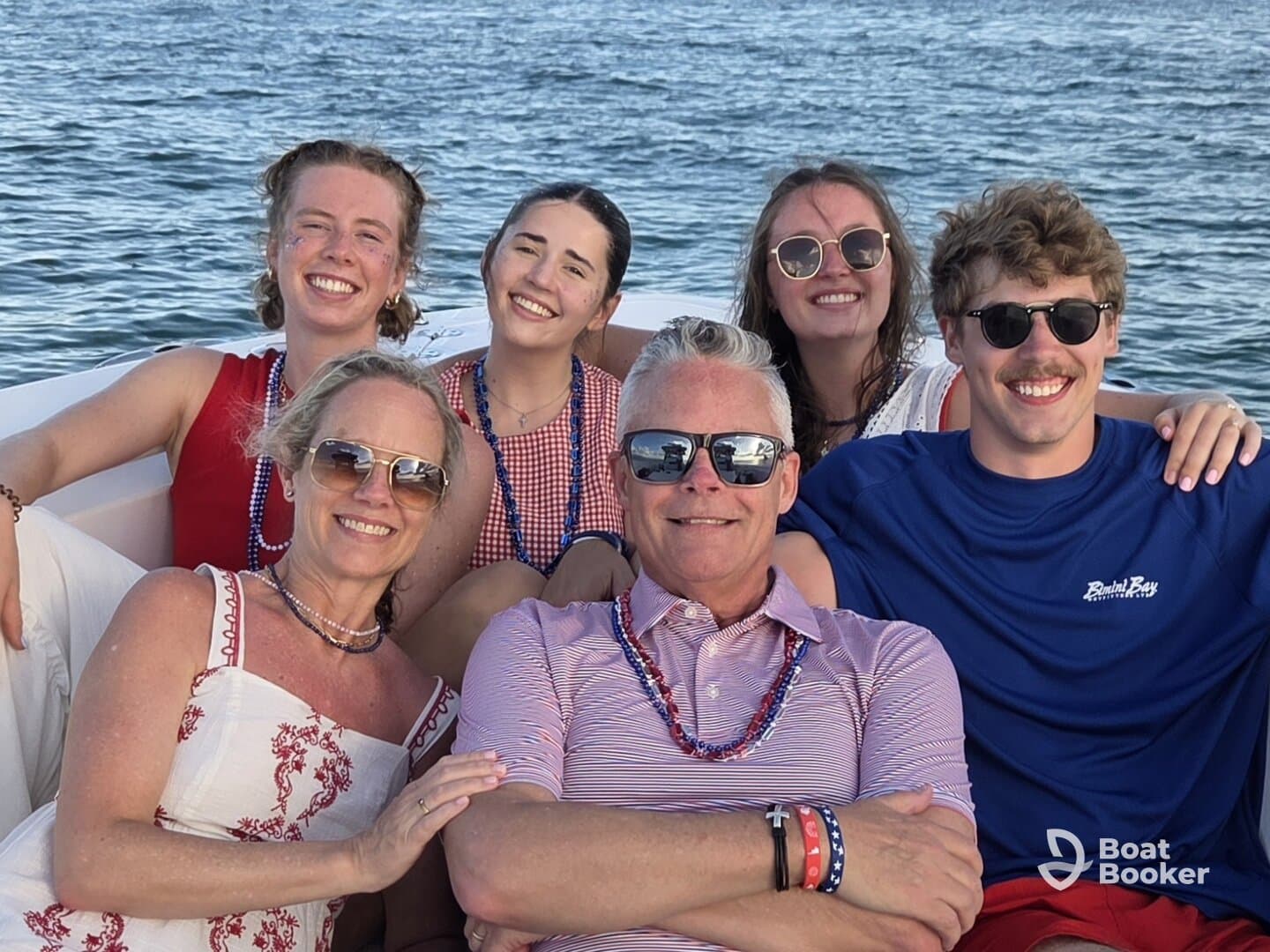 A joyful group of friends and family pose together on a boat, capturing a moment of celebration and togetherness on the water.