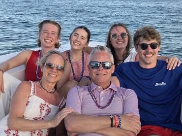 A joyful group of friends and family pose together on a boat, capturing a moment of celebration and togetherness on the water.