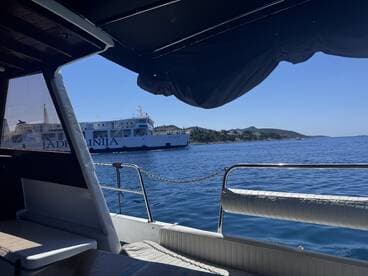 A view from inside a boat showcasing the seating area with a ferry passing by in the background, ideal for enjoying scenic coastal journeys.