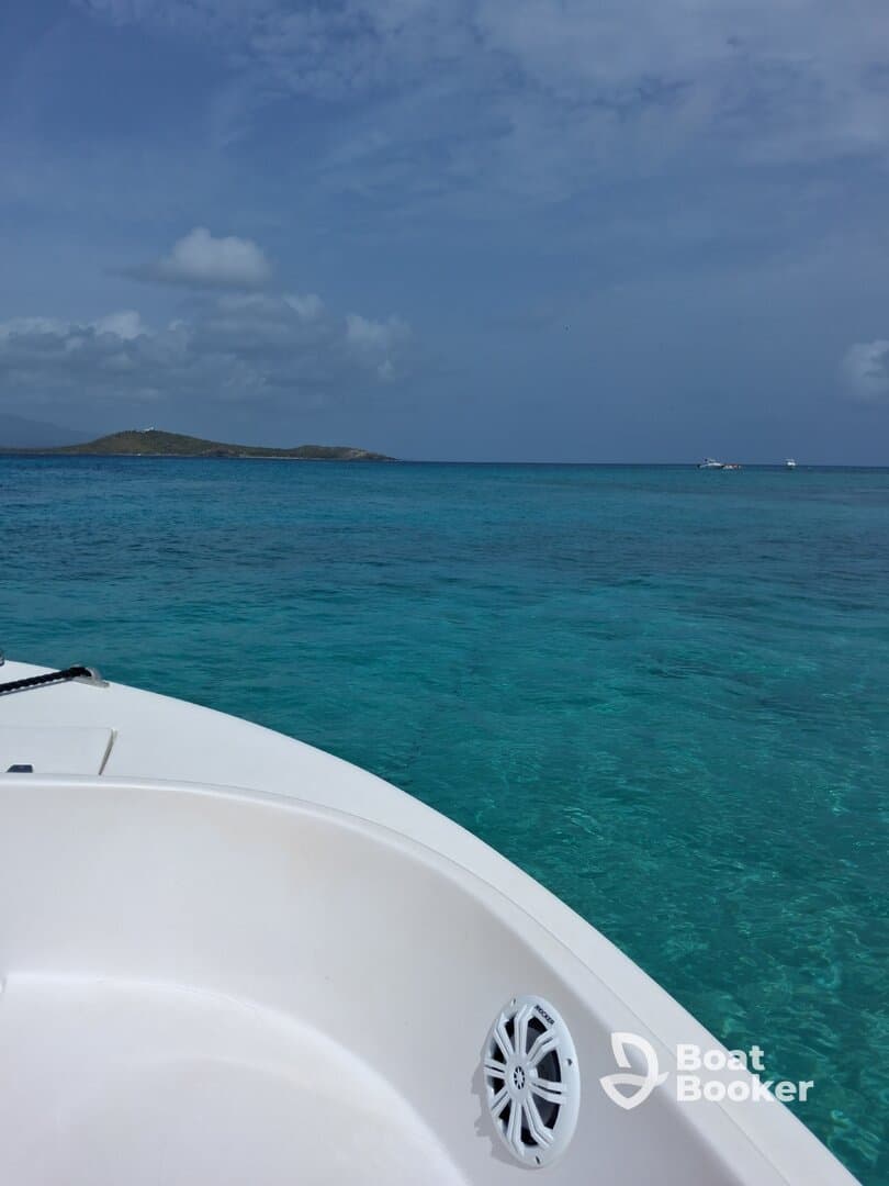 A stunning view from the bow of a boat, showcasing the vibrant turquoise waters and a distant island, perfect for a day of exploration and relaxation on the water.
