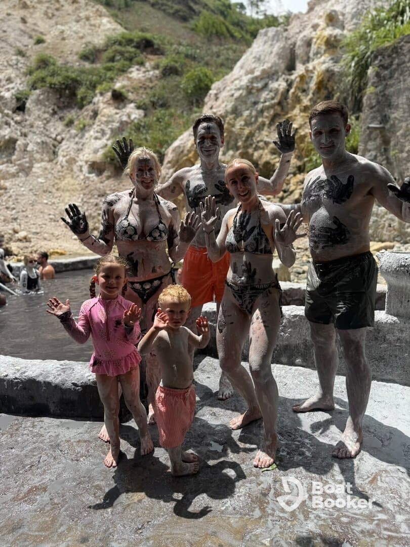 A joyful family enjoys a mud bath experience, showcasing their playful side while covered in mud — a fun and memorable activity during their adventure.