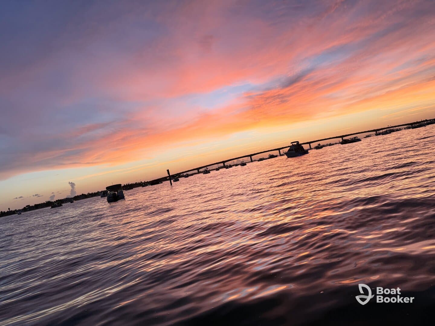 A stunning sunset over the water, with boats silhouetted against the vibrant sky — a perfect backdrop for evening cruises and relaxation on the water.