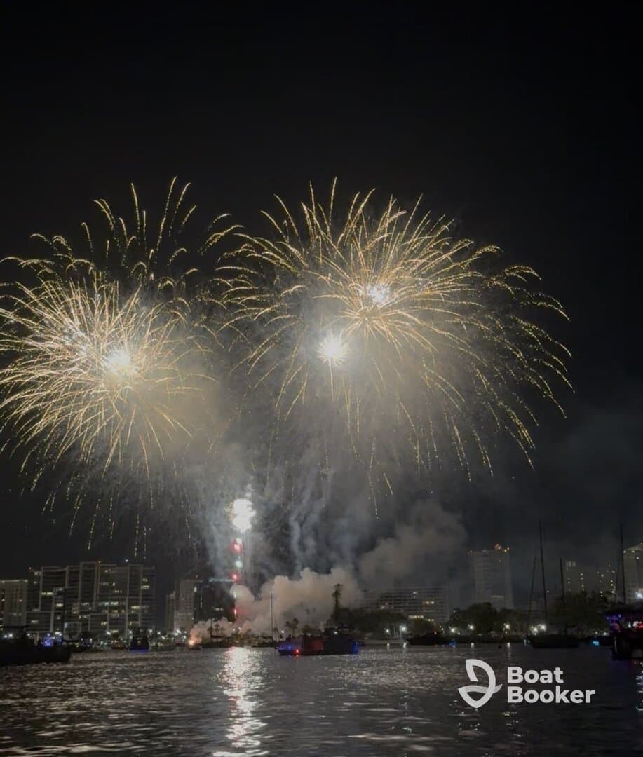 A stunning display of fireworks lights up the night sky over the city, creating a festive atmosphere perfect for celebrations on the water.