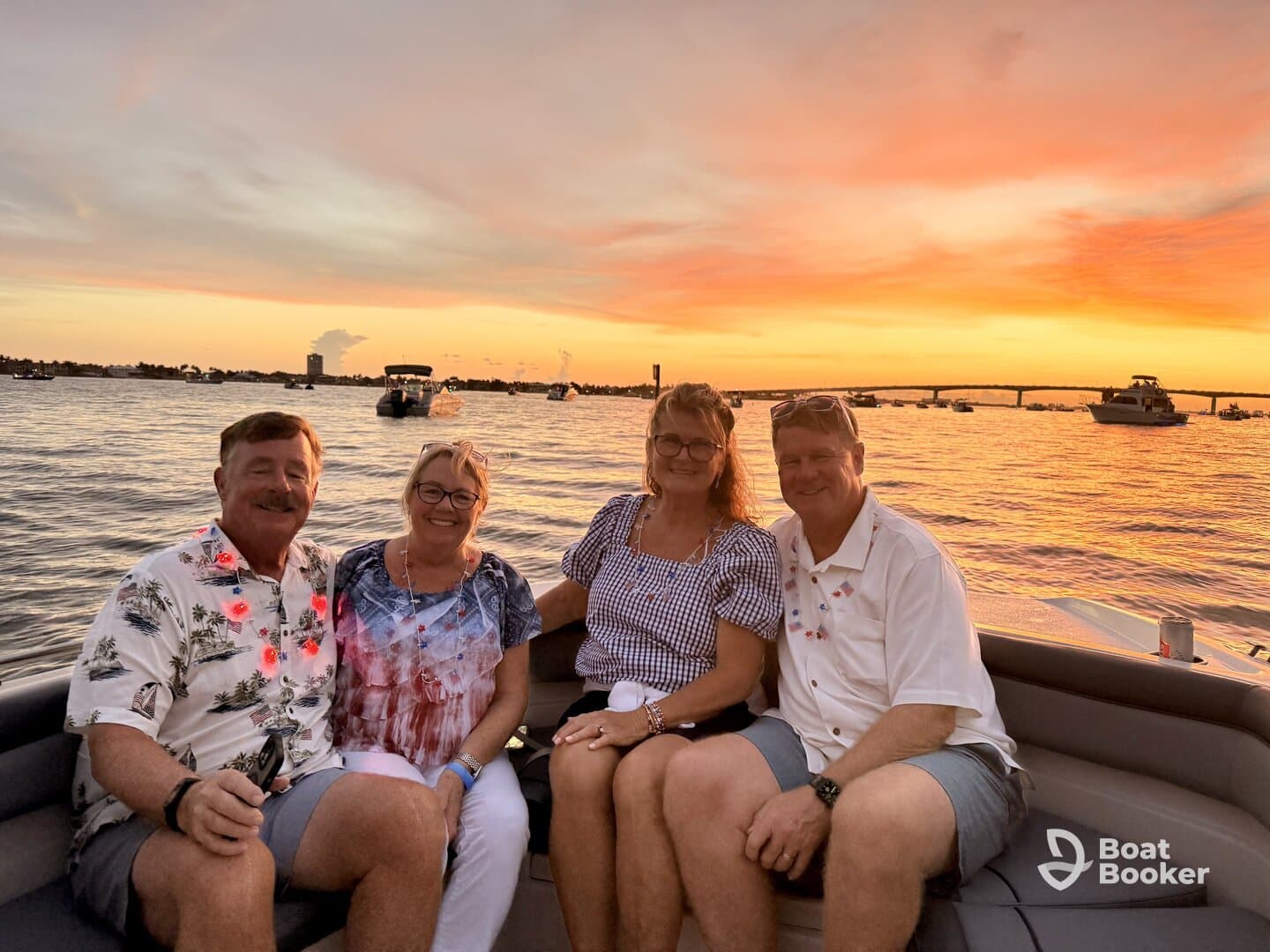 A cheerful group enjoys a sunset cruise on a boat, celebrating with drinks and laughter as the sun sets over the water.