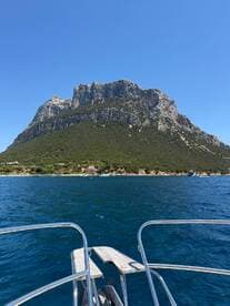 A stunning view of a mountainous coastline from the bow of a boat, showcasing the natural beauty of the area — perfect for scenic boat tours.