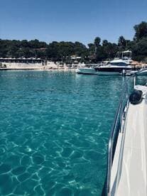 A serene view of boats docked in crystal-clear waters, showcasing the beauty of a coastal destination.