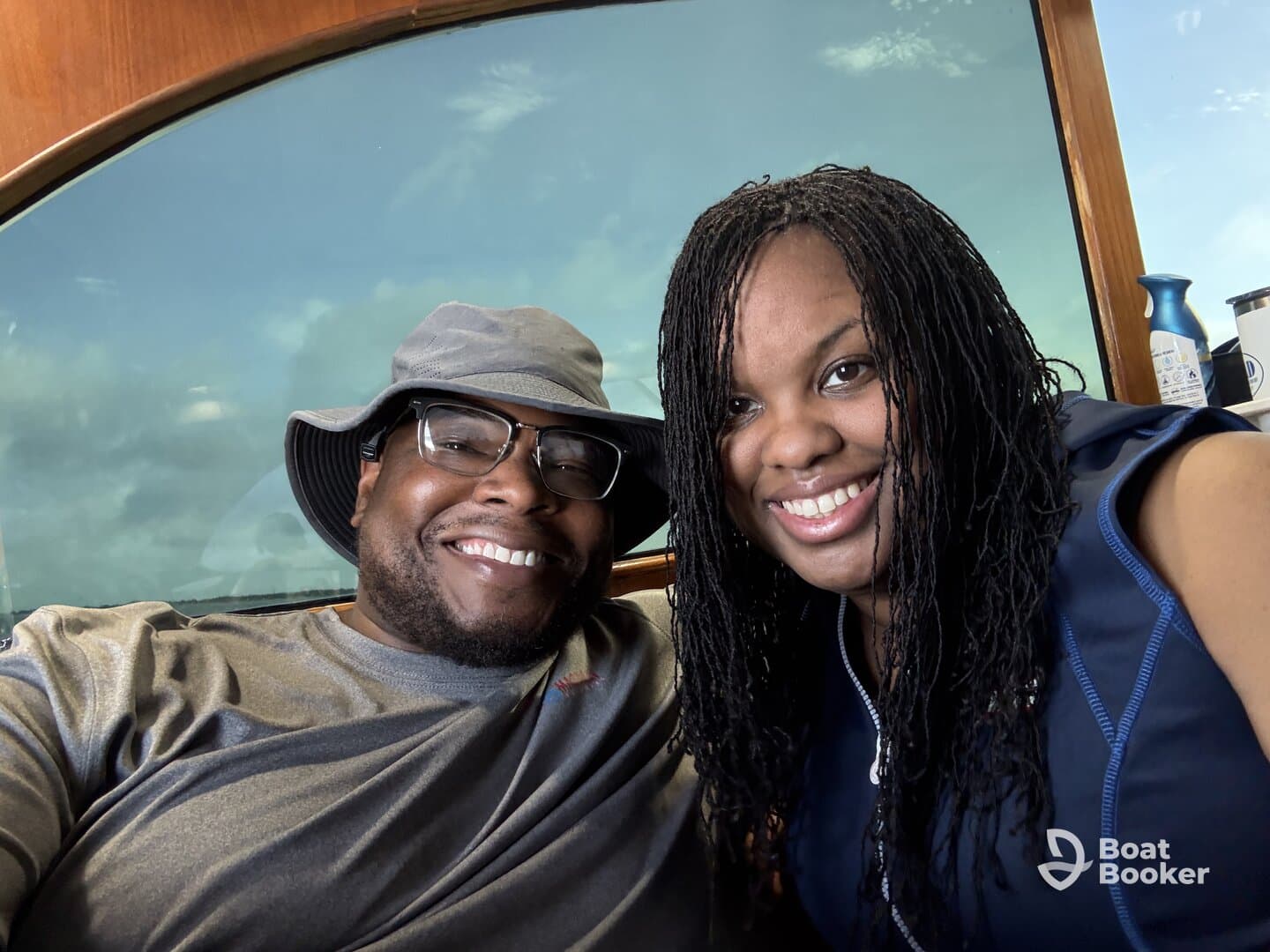 A joyful couple poses for a selfie inside a boat, showcasing their excitement for a memorable day on the water.