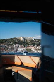 A stunning view from the boat showcasing a picturesque harbor and historic fortress, perfect for capturing the essence of coastal adventures.