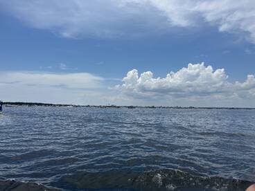 A scenic view of the water under a partly cloudy sky, capturing the essence of a tranquil day on the water.