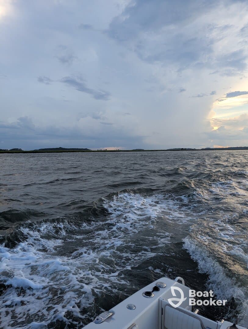 A scenic view of a boat underway, capturing the waves and a dramatic sky, perfect for showcasing the beauty of a day on the water.