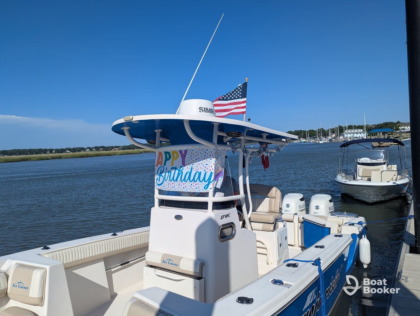 A well-decorated boat with a 'Happy Birthday' banner docked in calm waters, perfect for celebrating special occasions on the water.