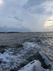 A scenic view of a boat underway, capturing the waves and a dramatic sky, perfect for showcasing the beauty of a day on the water.