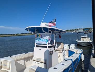 A well-decorated boat with a 'Happy Birthday' banner docked in calm waters, perfect for celebrating special occasions on the water.