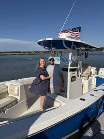 A couple celebrates a birthday on their boat, showcasing a festive atmosphere with decorations and a beautiful waterfront backdrop.